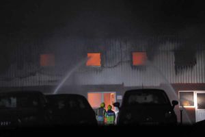 The store glows with the huge fire, which fire crews can be seen battling.