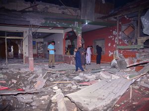Local residents and members of the media examine a building damaged by a suspected Indian missile attack near Muzaffarabad, the capital of Pakistan controlled Kashmir
