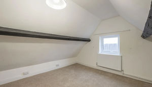 The upper most bedroom sits in the loft space and features original exposed beams and plenty of floor space