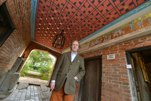 Artist Adam Dant with his 16-century style mural in the gatehouse at Upton Cressett Hall