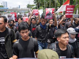 Protesters hold posters as they march during a rally against the new military law