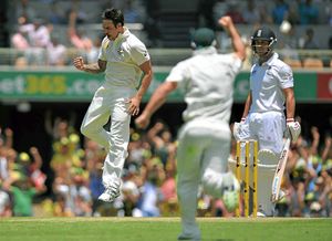 England's Jonathan Trott (right) looks-on as he loses his wicket to the bowling of Australia's Mitchell Johnson (left)