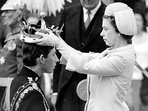 July 1, 1969: The Queen places the gem-encrusted gold coronet on the head of the Prince of Wales as he kneels before his mother at his investiture at Caernarvon Castle
