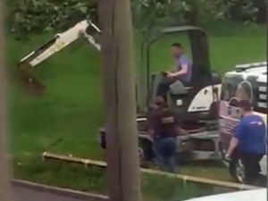 Supporting image for story: Watch the moment travellers used a DIGGER to break their way on to a playing field