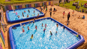 Children play in the Farmarama paddling pools with five gigantic pools this year making it the biggest party yet