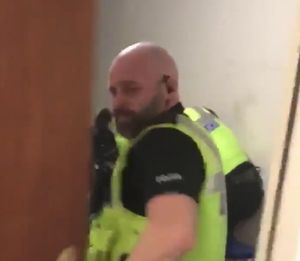 The police officer closing the door on the person recording the video