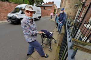 Lucy Shrank attempts to push a pushchair onto the pavement