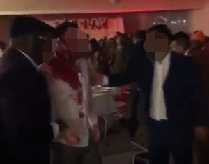 A man with a blood splattered shirt is helped by two other men. Image: Facebook