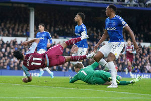 Aston Villa's Ollie Watkins, top, falls after failing to score in front of Everton's goalkeeper Jordan Pickford