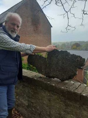 Martin Crowdy shows a 15kg lump of stone that was about to fall off the wall before he managed to pull it back into the churchyard. Photo: Martin Crowdy
