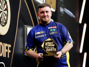 Luke Littler poses with the trophy after winning night seven of the BetMGM Premier League in Cardiff