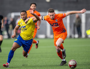 Corby's captain Rory McAuley holds off Khalsa's Andre Landell. (Image by Jim Wall)