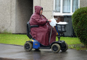 One Dudley resident navigates their way along a wet pavement