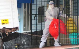 A health worker wearing protective gear disposes of biohazard waste from a Nipah virus isolation centre. | AFP via Getty Images
