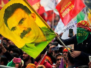 A youth holds a flag with the image of Abdullah Ocalan