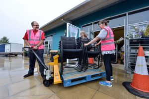 Jacqui Idiens help Phil Wilson with some chairs that are going to a lock-up for storage while they look for a new site