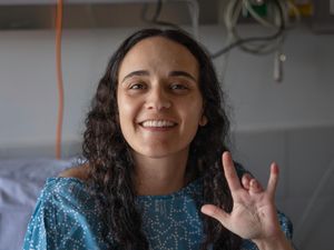 British Israeli citizen Emily Damari shows the injuries to her left hand