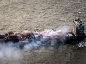 View from above of container ship Solong at sea, burnt-out and smoking