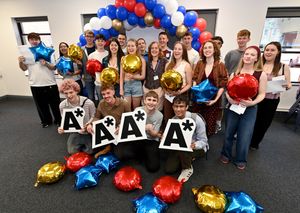 Students celebrate their top A level results at King Edward VI College in Stourbridge. Pictured centre with her students is principle Holly Bembridge