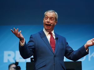 Reform UK leader Nigel Farage speaking on stage