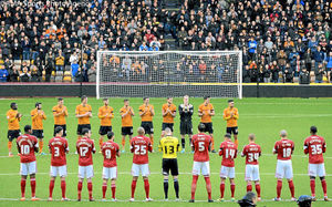 Players of Wolverhampton Wanderers observe a minutes applause in memory of former Wolverhampton Wanderers and England goalkeeper Bert Williams, who passed away on Sunday at the age of 93.