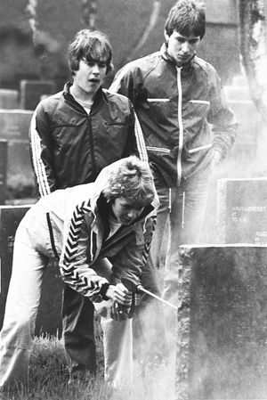 Some of the young German teenagers from the Bremen sports youth party using a pressure spray to clean headstones in August 1980.