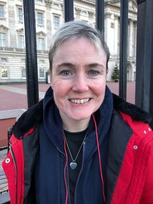 Lisa Murray-Lang with Spud in a vial around her neck outside Buckingham Palace. Photo: Lisa Murray-Lang/SWNS