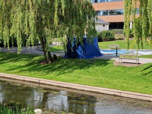 A tent was seen between the river and the children's play area