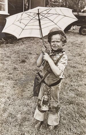 Wedges Mills Carnival, 1977. Waiting for the rain to stop is Phillip Reaney, dressed as a miner, carrying an umbrella in the rain.