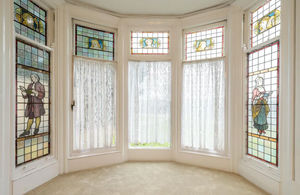 The main living room features original stained glass windows