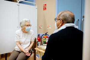LAST COPYRIGHT SHROPSHIRE STAR JAMIE RICKETTS 14/01/2021 - Woodside Pharmacy in Telford is the first in the borough to deliver the Covid Vaccine. In Picture: Dorothy Georgiou 87 from Wellington, Telford has the vaccine by Sarwan Samrai (Director of Woodside Pharmacy)
