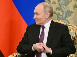 Vladimir Putin in front of a Russian flag