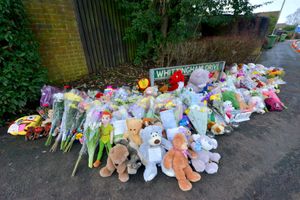 Floral tributes have been placed near the home after people living nearby were rocked by the tragedy