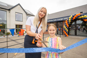 Sales advisor Olivia Ingles helps Indie cut the ribbon to officially open the Lorimer showhome