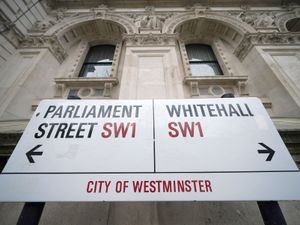 A street sign pointing to Parliament Street SW1 to the left and Whitehall SW1 to the right