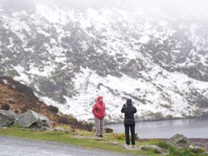 People looking at the snow at Lough Bray Upper on Powerscourt Mountain in co Wicklow (PA)