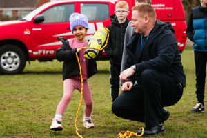 Market Drayton Fire Service are providing half term activities at The Zone in Market Drayton. Here, Firefighter Barry Plant is teaching children how to use a throw line as well as trying on Fire Helmets. In Picture: Sophia and Barry Plant