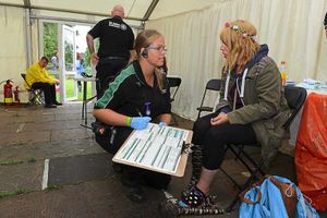 A St John Ambulance volunteer helps an injured festival-goer at V.