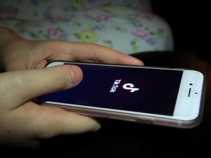 A young girl uses the TikTok app on a smartphone