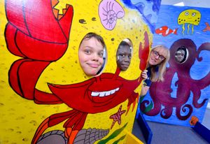 River Douglas, Raimundo Bassil and Tina Bassil pose in the picture boards they helped create with Diane Garbett, Youth and Community Worker with Hope Community Project