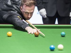 Judd Trump cues a shot from the baulk like against Zhou Yuelong