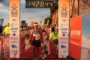 Bharat Rai crossing the Outlaw Triathlon finish line with daughter Aaliya, left, his son Aryan and niece Alyssia