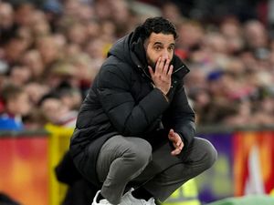 Manchester United manager Ruben Amorim crouches on the touchline during match against Fulham