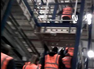 Workers climb steps close together