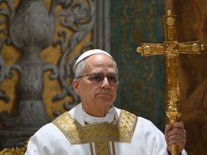 Pope Leo XIV holding a large golden cross