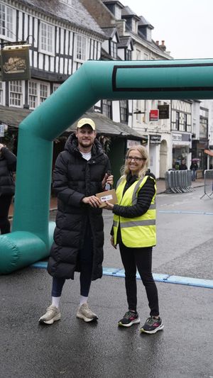 Alex Burrows from Birchfield Harriers receives his cash prize after winning the race in a new record time of 33 minutes, 30 seconds.