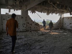 Members of the media walk around a mosque building damaged by a suspected Indian missile attack, in Kotli, a town in Pakistan-controlled Kashmir