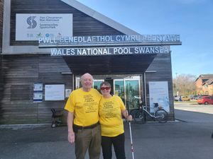 Two veterans wearing yellow t-shirts outside the Wales National Pool Swansea