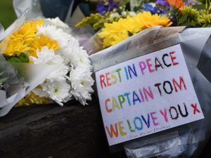 Supporting image for story: Floral tributes to Captain Tom laid at village green near his house
