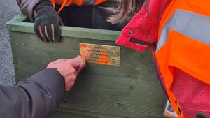 Friends of Wellington Station members attaching the plaque, engraved by Leslie Gough of The Wellington Cobbler.